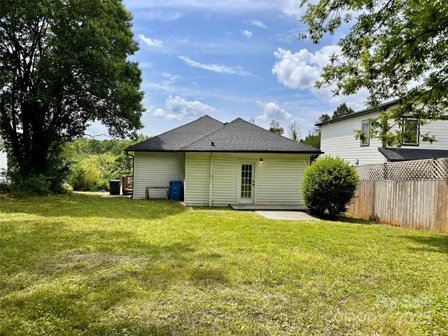a view of a yard with a house and large trees