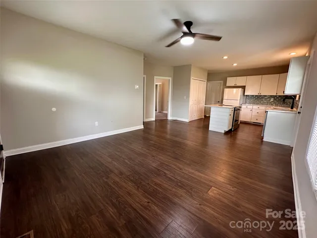 a kitchen with stainless steel appliances granite countertop a sink a stove and a wooden floors