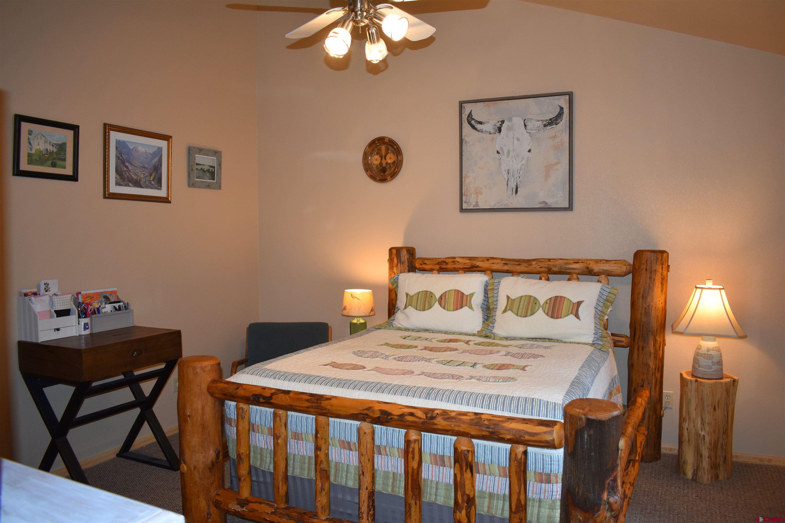 1570 Oak Street Ouray, CO 81427 - Photo 28 of 35 a bedroom with a bed and a lamp with paintings on wall