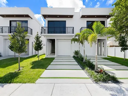 a front view of a house with a garden and plants