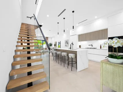 a kitchen with stainless steel appliances kitchen island granite countertop a sink and a living room view