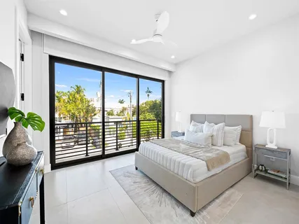 a bathroom with a toilet a sink a mirror and a window