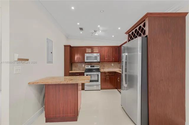 a kitchen with stainless steel appliances granite countertop a refrigerator and a stove top oven
