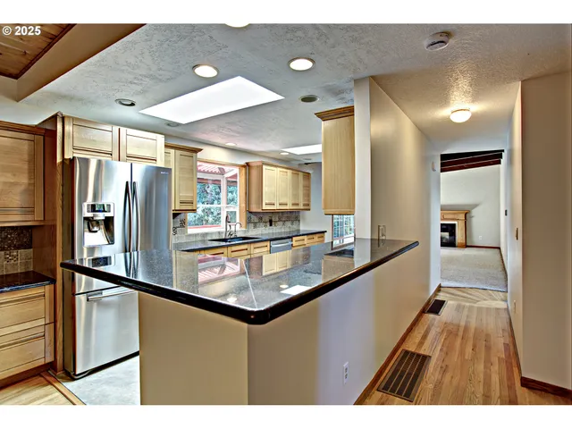 a kitchen with stainless steel appliances granite countertop a refrigerator and a sink