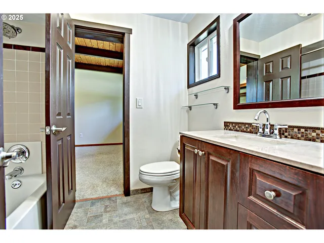 a bathroom with a sink a toilet and a mirror