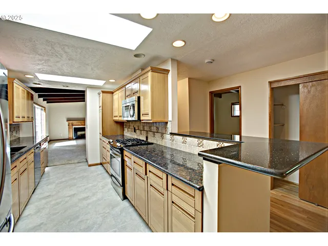 a kitchen with stainless steel appliances granite countertop a sink and cabinets