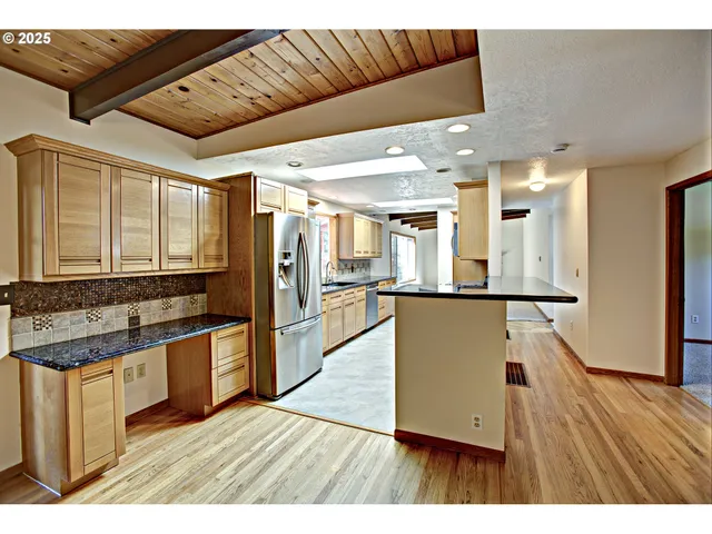 a living room with stainless steel appliances kitchen island granite countertop furniture and a large window