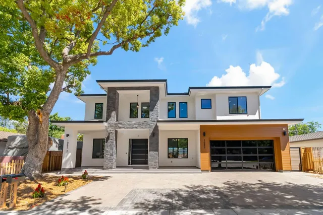 a front view of a house with a tree