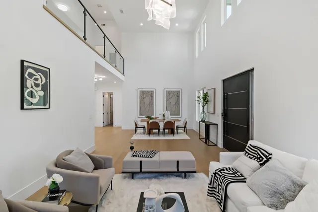 a living room with wooden floor furniture and a chandelier