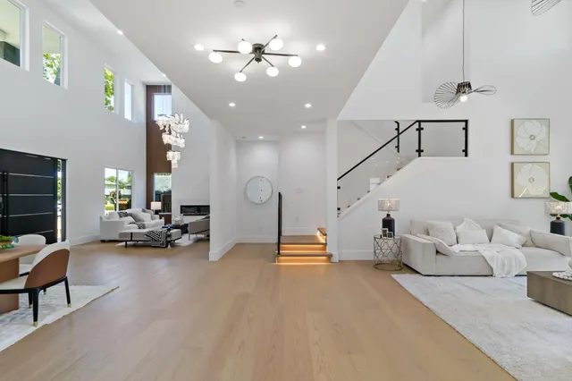 a living room with furniture large windows and flat screen tv