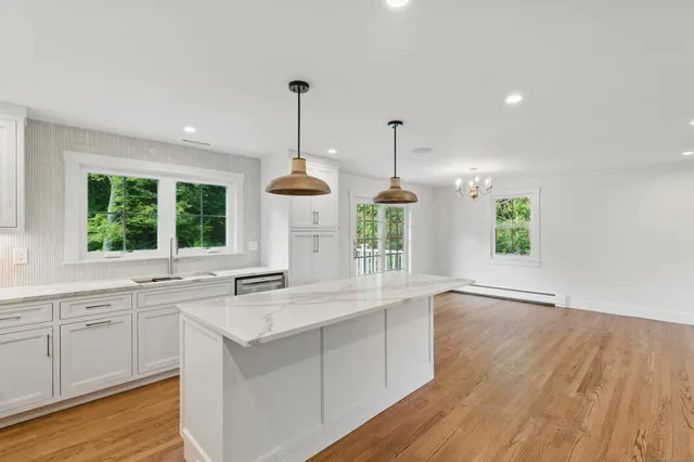 a kitchen with a sink window and wooden floor