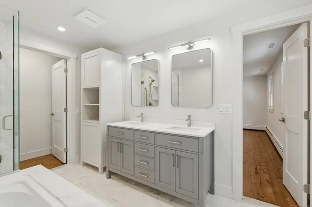 a spacious bathroom with a double vanity sink mirror and double