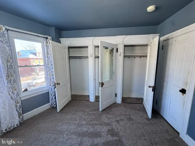 an empty room with windows and closet