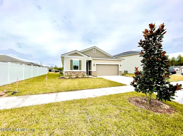 a kitchen with stainless steel appliances granite countertop a refrigerator a sink a stove and white cabinets with wooden floor