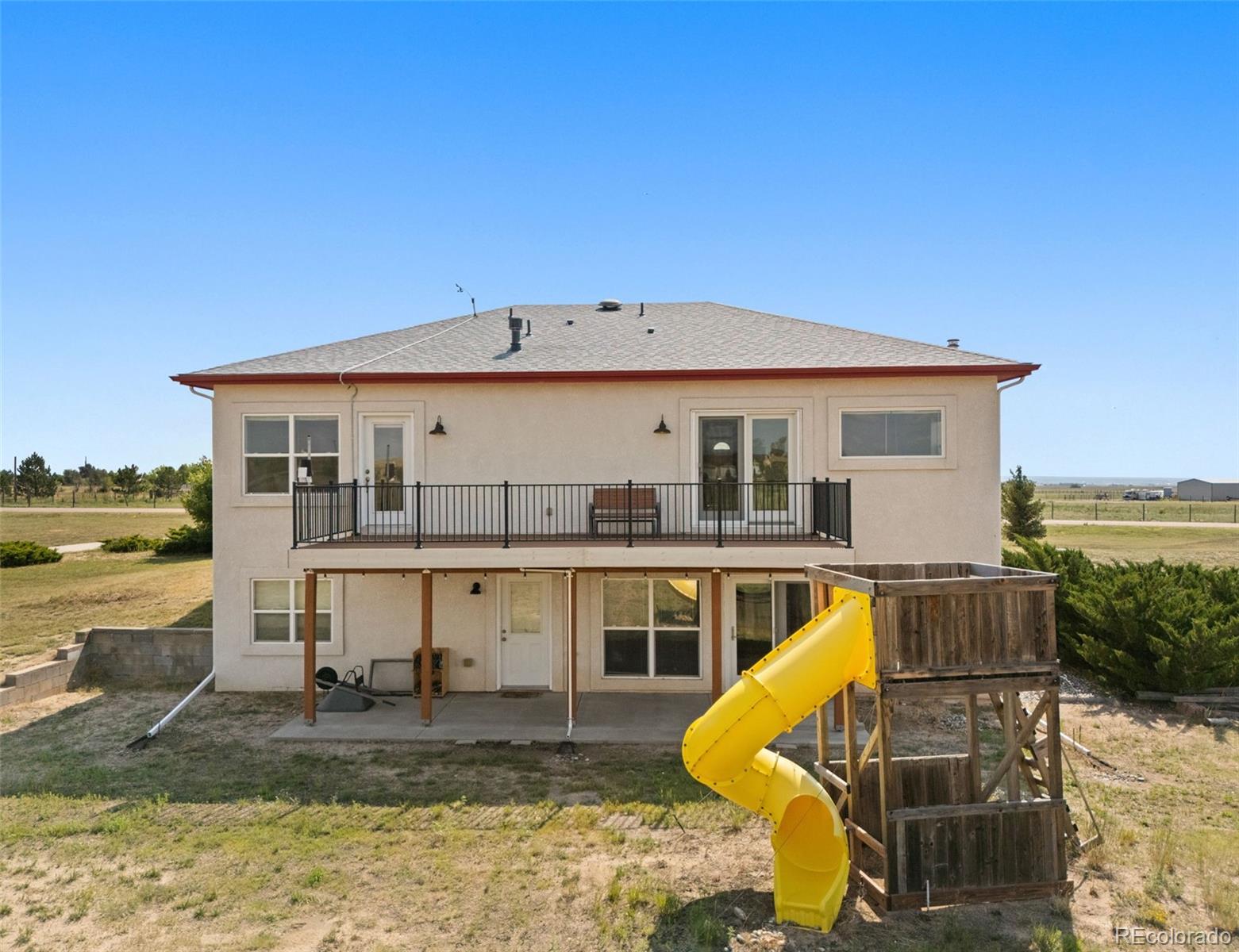 11424 McKissick Road Peyton, CO 80831 - Photo 29 of 32 a view of a house with pool chairs and wooden fence