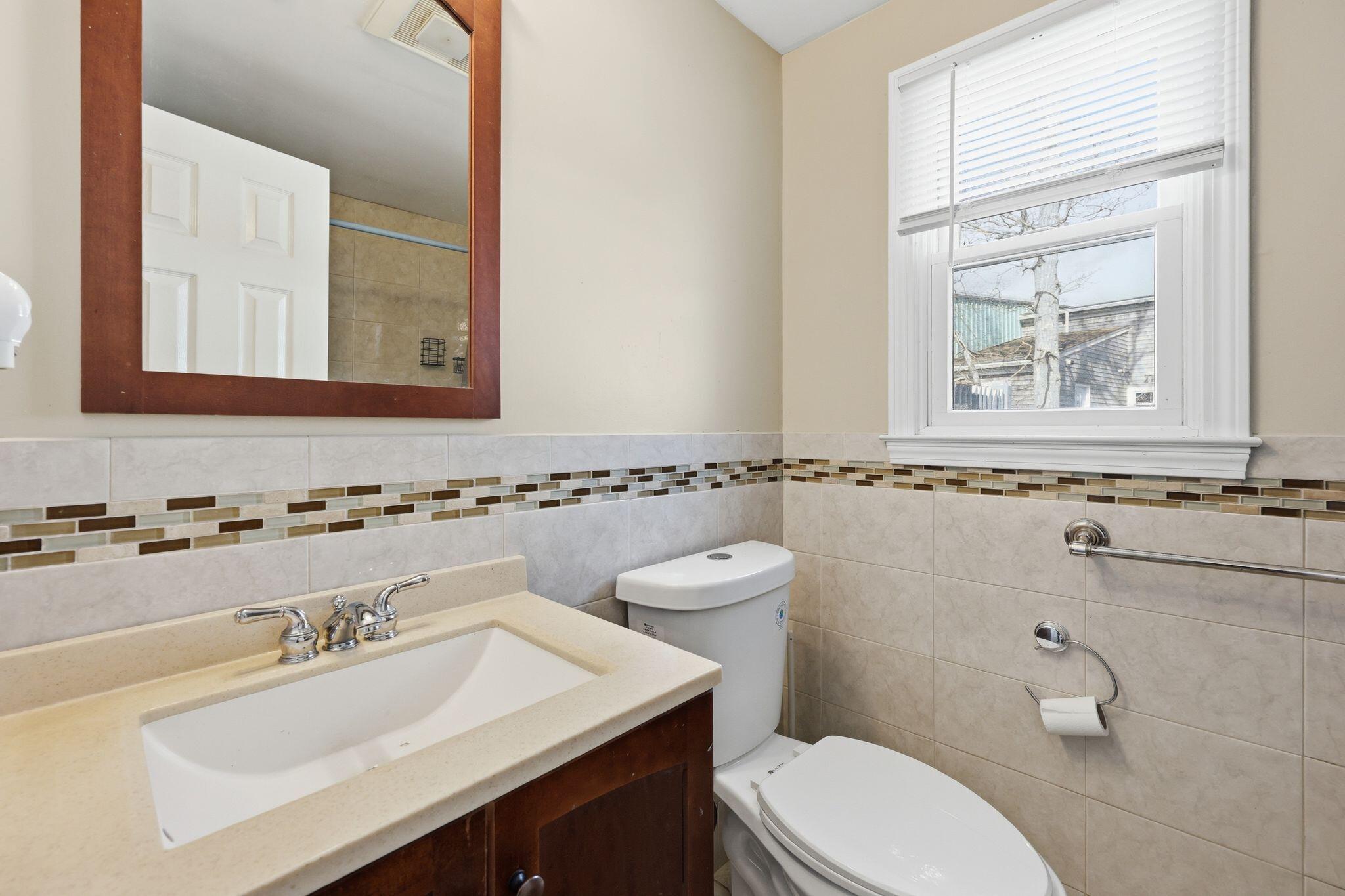 26 Howes Road South Yarmouth, MA 02664 - Photo 31 of 42 a bathroom with a sink a toilet and a mirror