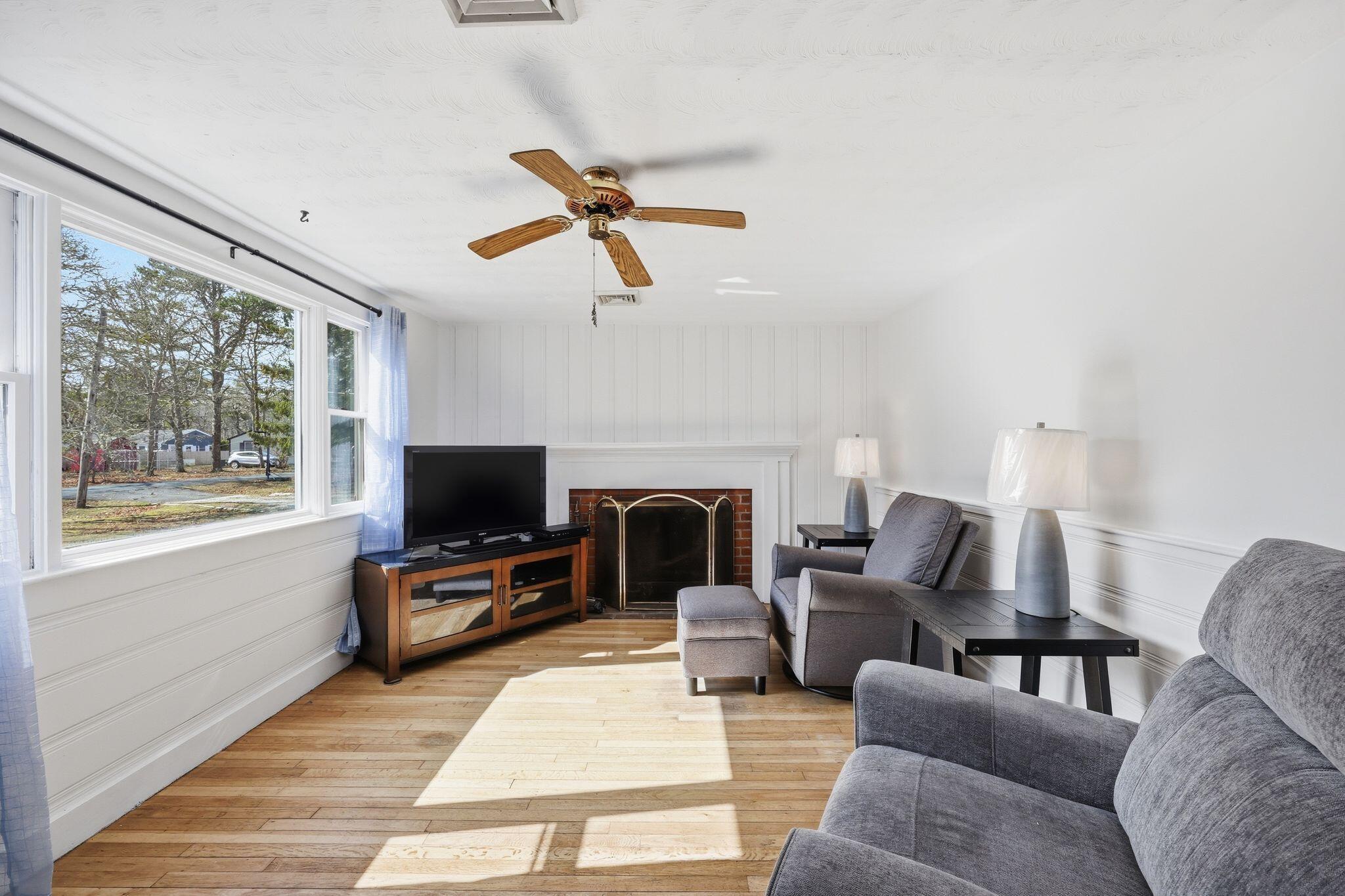 26 Howes Road South Yarmouth, MA 02664 - Photo 10 of 42 a living room with furniture a fireplace and a flat screen tv