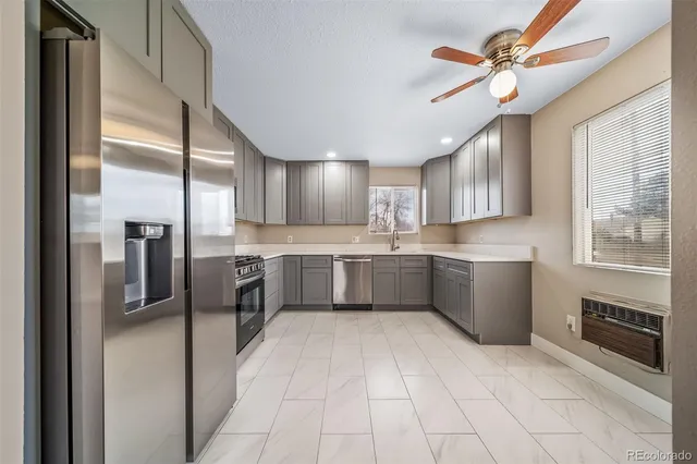 a kitchen with stainless steel appliances granite countertop a refrigerator and a stove top oven