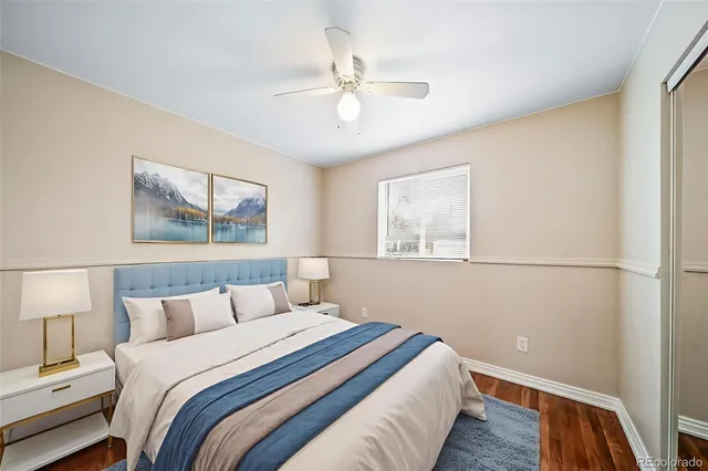an empty room with wooden floor and fan