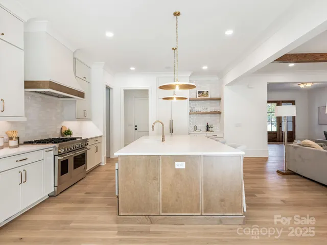 a kitchen with kitchen island a stove a sink a center island and wooden floor