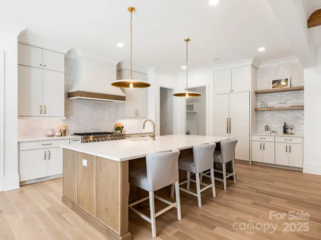a kitchen with a white table chairs and white cabinets