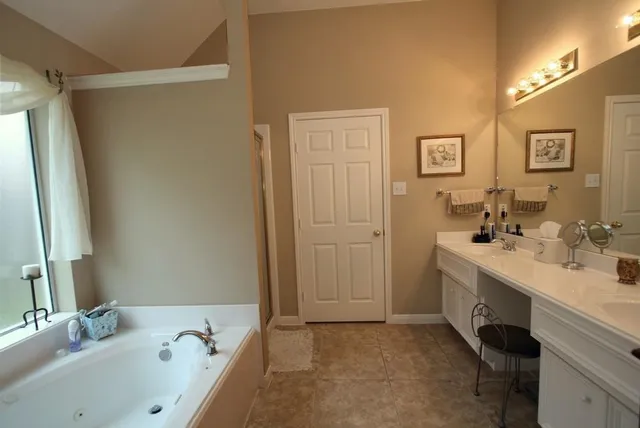 a bathroom with a tub sink and mirror