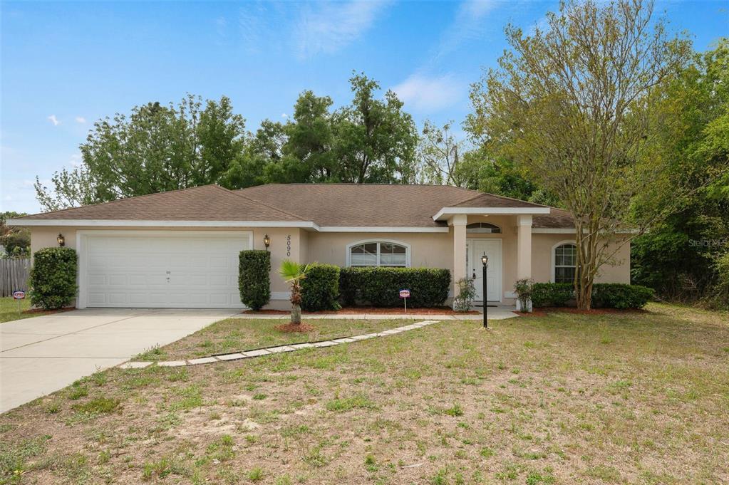 5090 Southeast 28th Street Ocala, FL 34480 - Photo 2 of 35 a front view of house with yard and trees in the background