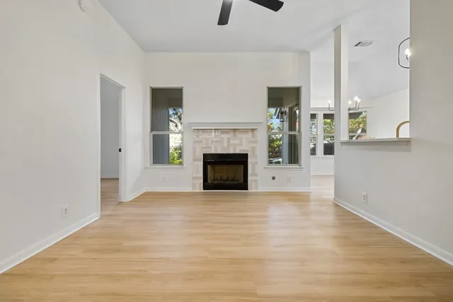 a view of empty room with wooden floor and fireplace