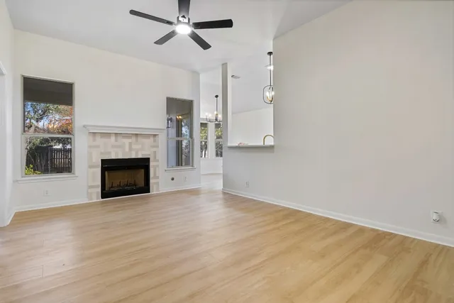 a view of empty room with wooden floor and fireplace