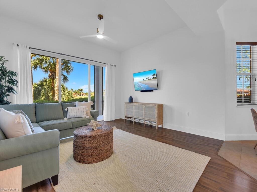 2710 Callista Court, Unit 104 Naples, FL 34114 - Photo 17 of 43 Living area with a healthy amount of sunlight, wood finished floors, baseboards, and a ceiling fan