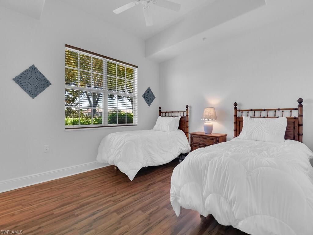2710 Callista Court, Unit 104 Naples, FL 34114 - Photo 18 of 43 Bedroom featuring baseboards, wood finished floors, and a ceiling fan