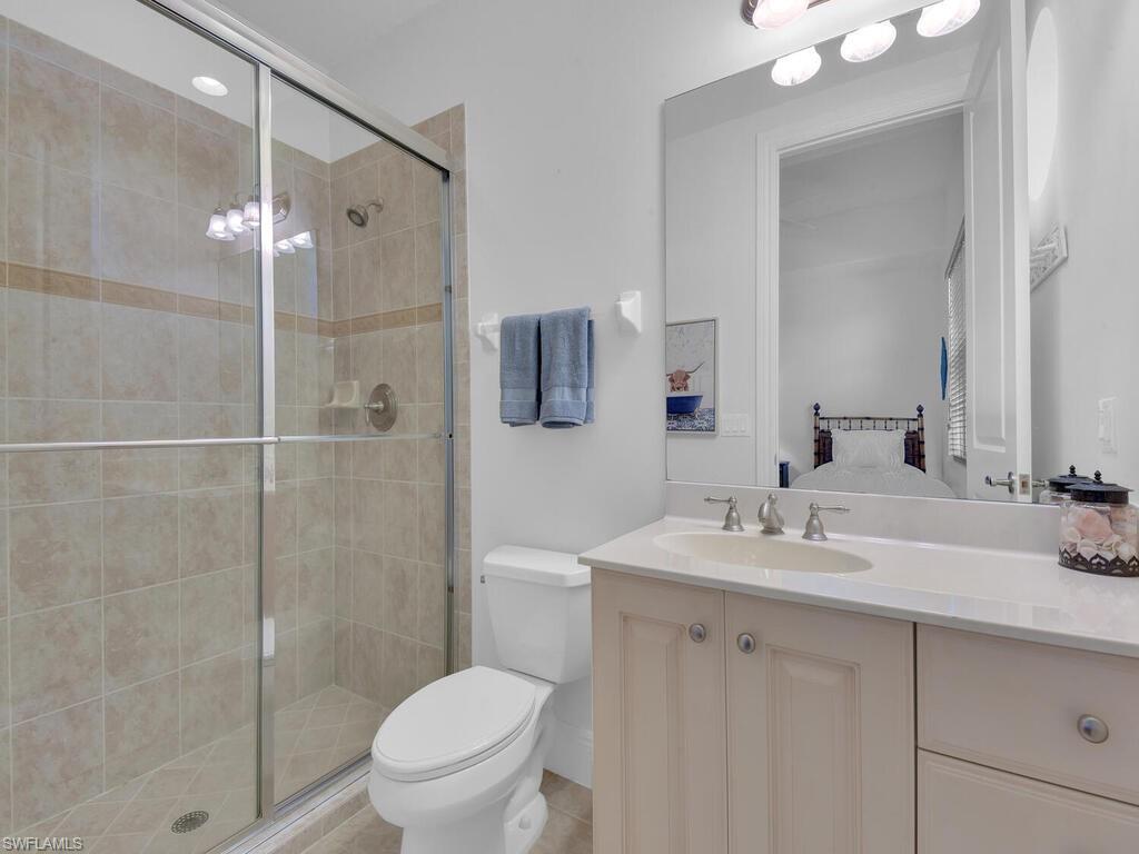 2710 Callista Court, Unit 104 Naples, FL 34114 - Photo 20 of 43 Full bath with toilet, a stall shower, and vanity