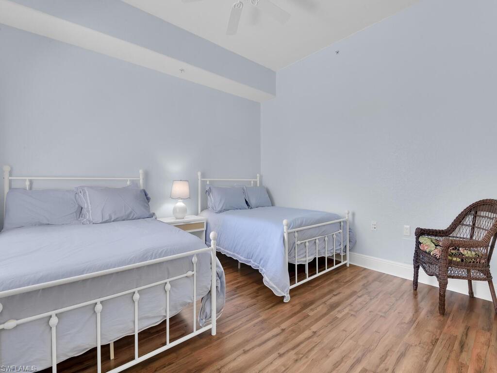 2710 Callista Court, Unit 104 Naples, FL 34114 - Photo 21 of 43 Bedroom with baseboards, ceiling fan, and wood finished floors