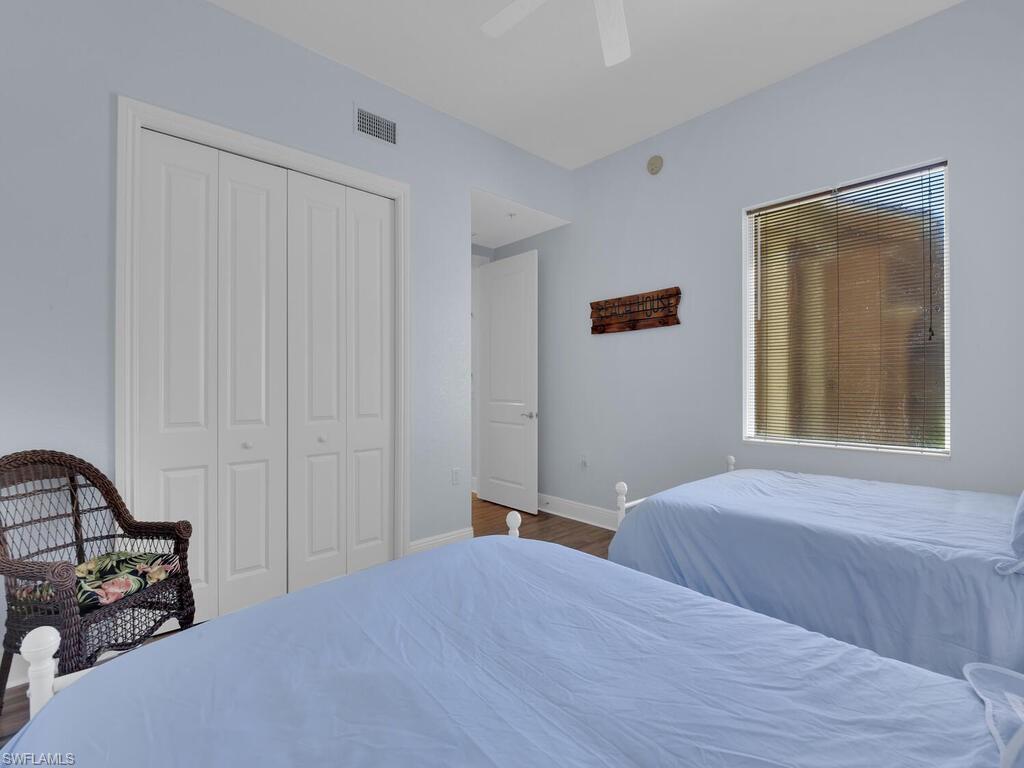 2710 Callista Court, Unit 104 Naples, FL 34114 - Photo 22 of 43 Bedroom with a closet, a ceiling fan, wood finished floors, baseboards, and visible vents