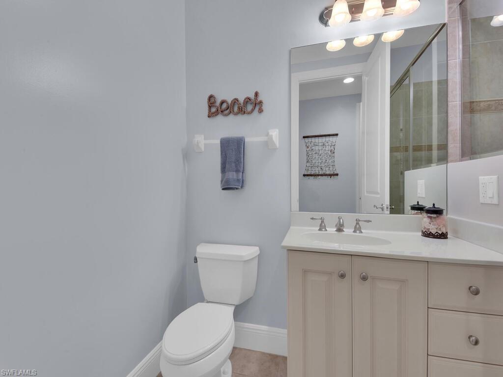 2710 Callista Court, Unit 104 Naples, FL 34114 - Photo 23 of 43 Full bathroom with vanity, a tile shower, toilet, baseboards, and tile patterned floors