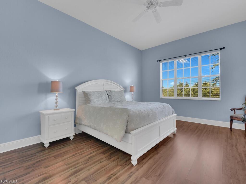 2710 Callista Court, Unit 104 Naples, FL 34114 - Photo 25 of 43 Bedroom with baseboards, wood finished floors, and a ceiling fan