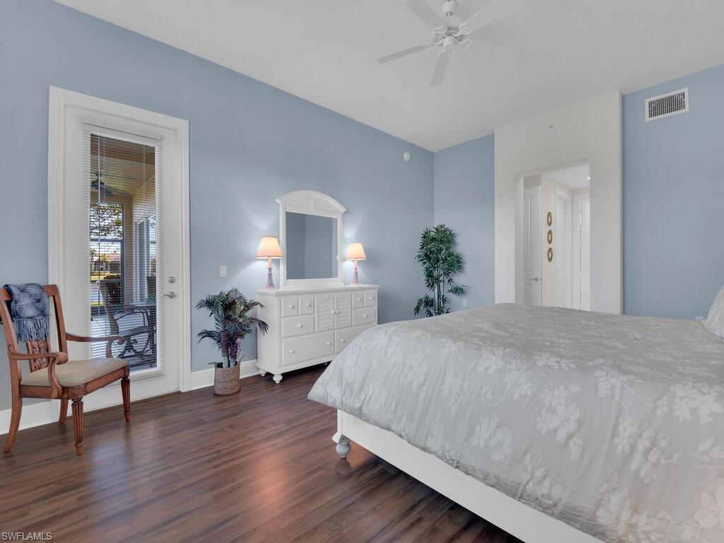2710 Callista Court, Unit 104 Naples, FL 34114 - Photo 26 of 43 Bedroom with visible vents, baseboards, access to outside, a ceiling fan, and dark wood-type flooring