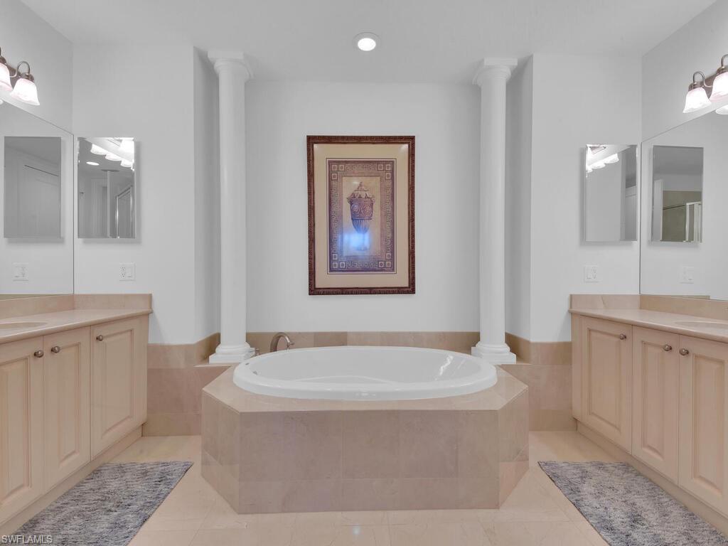2710 Callista Court, Unit 104 Naples, FL 34114 - Photo 28 of 43 Bathroom featuring a sink, two vanities, a bath, and ornate columns
