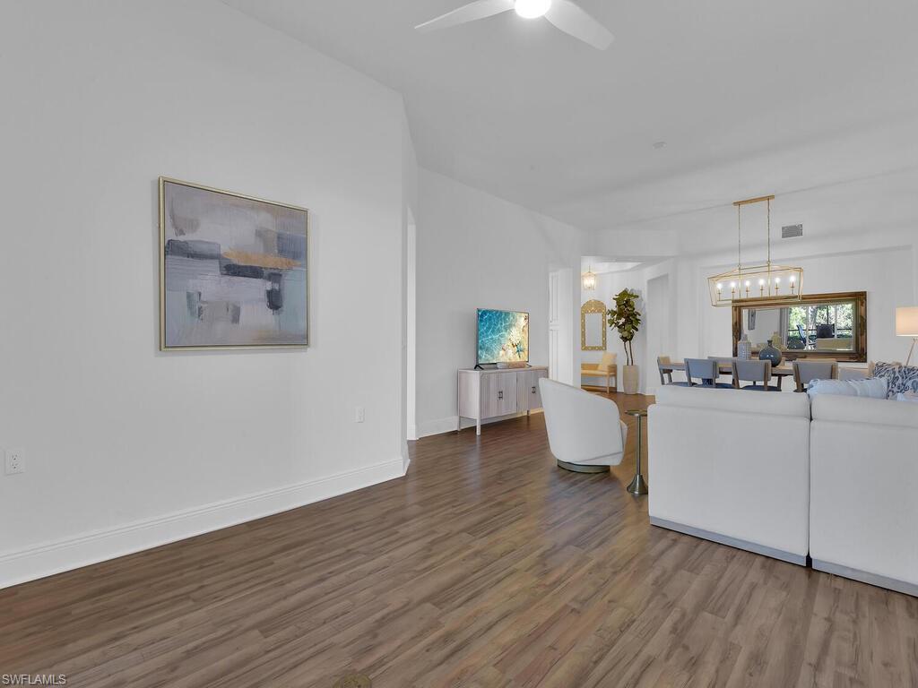2710 Callista Court, Unit 104 Naples, FL 34114 - Photo 8 of 43 Living area with baseboards, visible vents, wood finished floors, and a ceiling fan