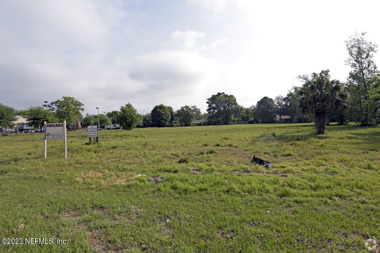 a view of a green field with wooden fence