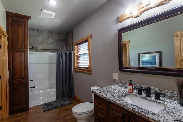 a bathroom with a granite countertop sink toilet and shower