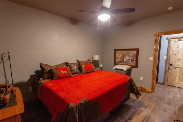 a bedroom with a bed a dresser and painting on the wall