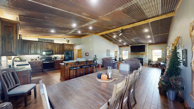 a living room with lots of furniture and view of kitchen