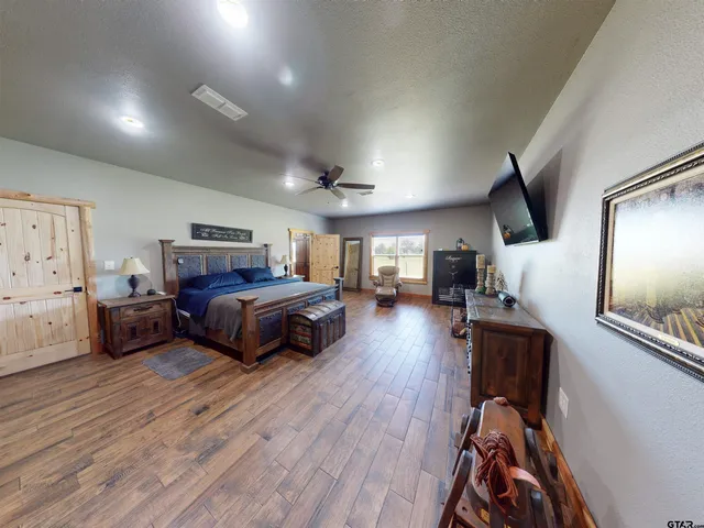 a bedroom with furniture and a wooden floor