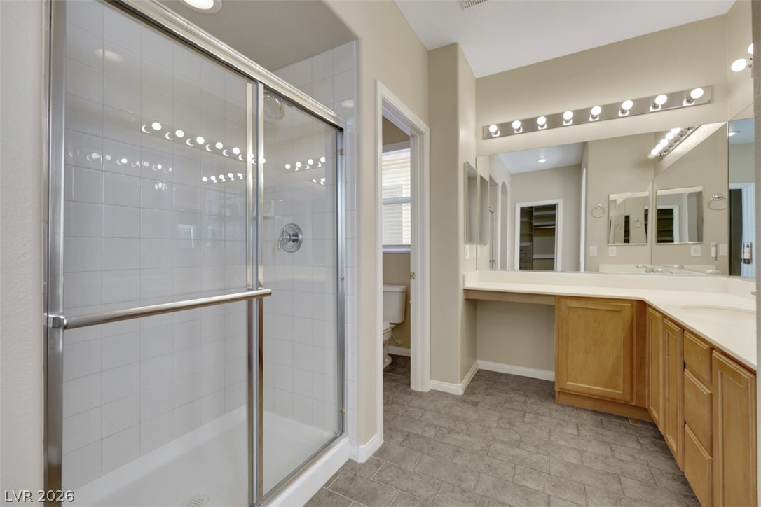 10328 Hawk Ravine Street Las Vegas, NV 89178 - Photo 42 of 55 A spacious primary bathroom boasts a walk-in shower and a generously sized double vanity with ample counter space.
