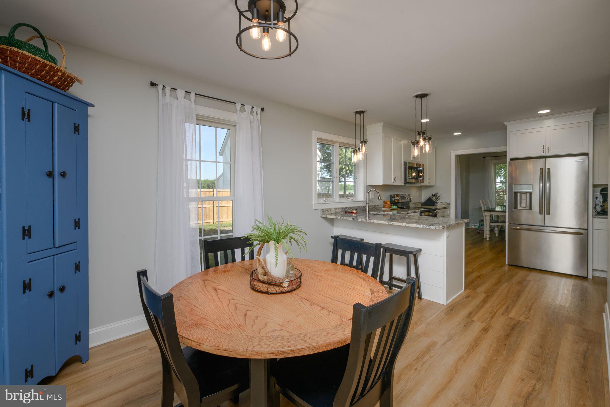 2649 Roberts Station Road Ingleside, MD 21644 - Photo 17 of 47 a kitchen with a dining table chairs and refrigerator
