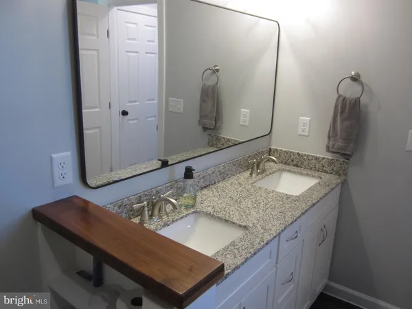 a bathroom with a granite countertop sink and a mirror