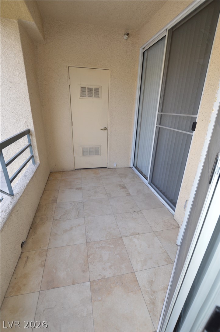 210 East Flamingo Road, Unit 112 Las Vegas, NV 89169 - Photo 27 of 59 Tiled flooring and stucco walls define this private outdoor balcony area.