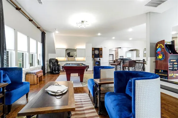 a living room with furniture kitchen view and large windows