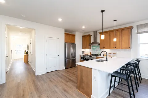 a kitchen with refrigerator a sink and chairs